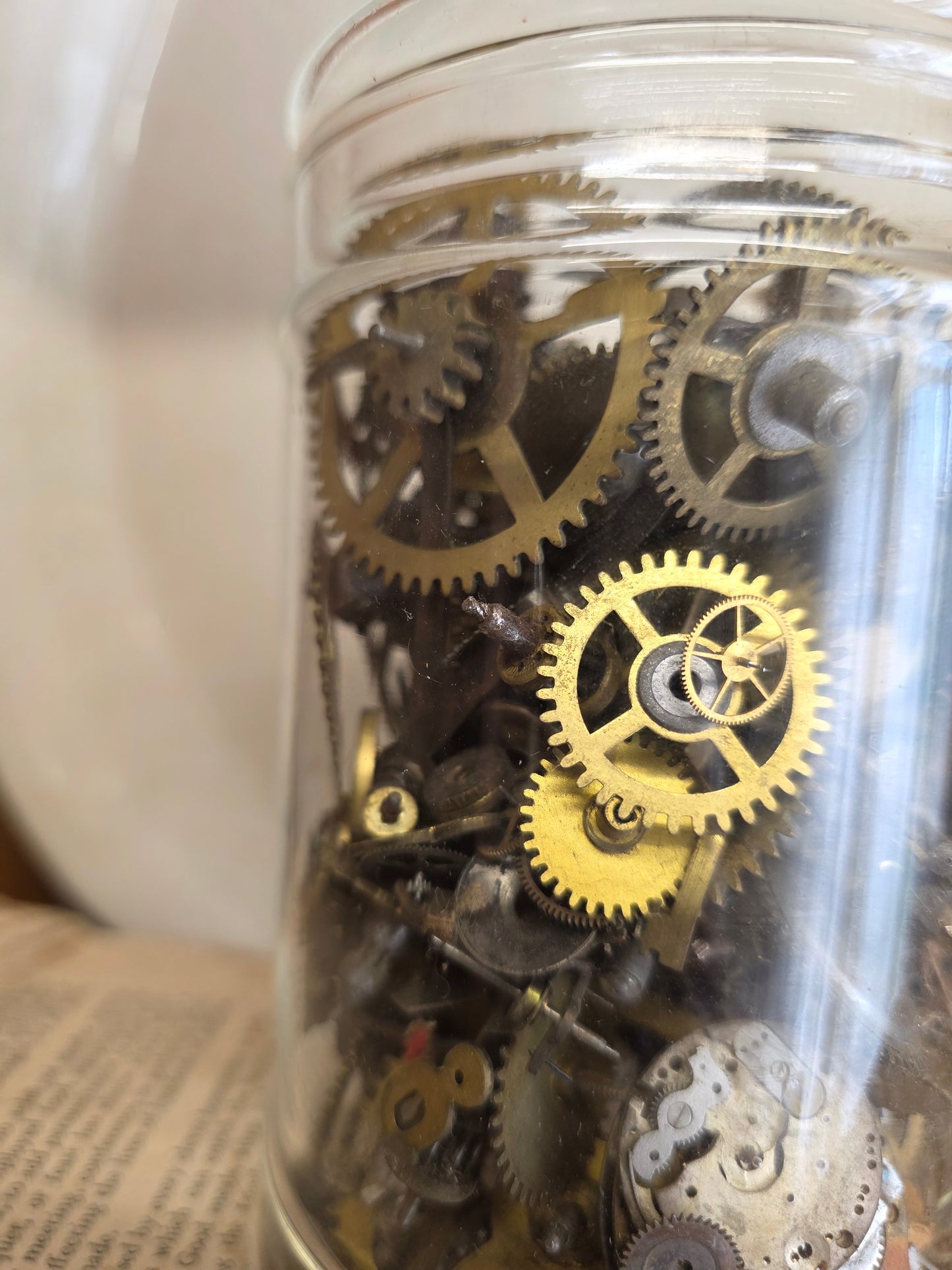 glass apothecary jar of brass clock parts