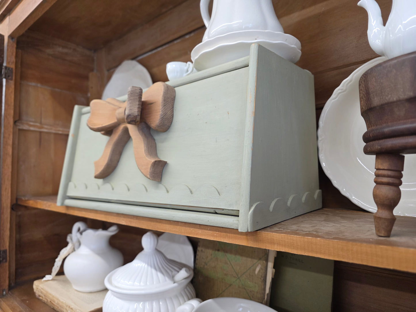 Green breadbox with scalloped details and large wooden bow