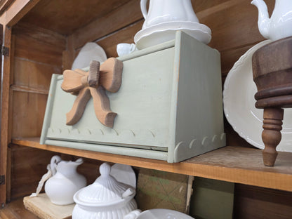 Green breadbox with scalloped details and large wooden bow