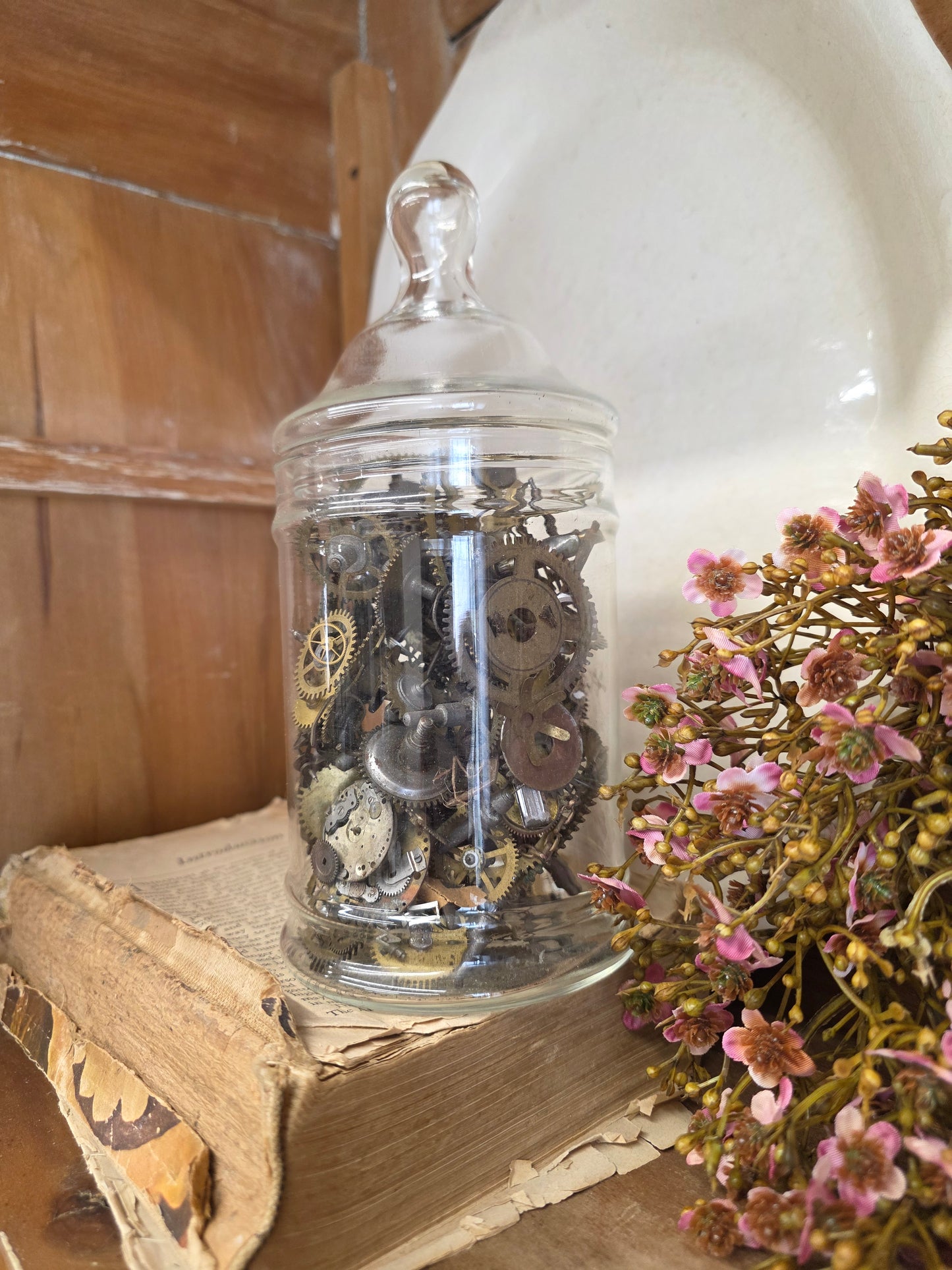 glass apothecary jar of brass clock parts