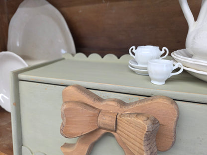 Green breadbox with scalloped details and large wooden bow