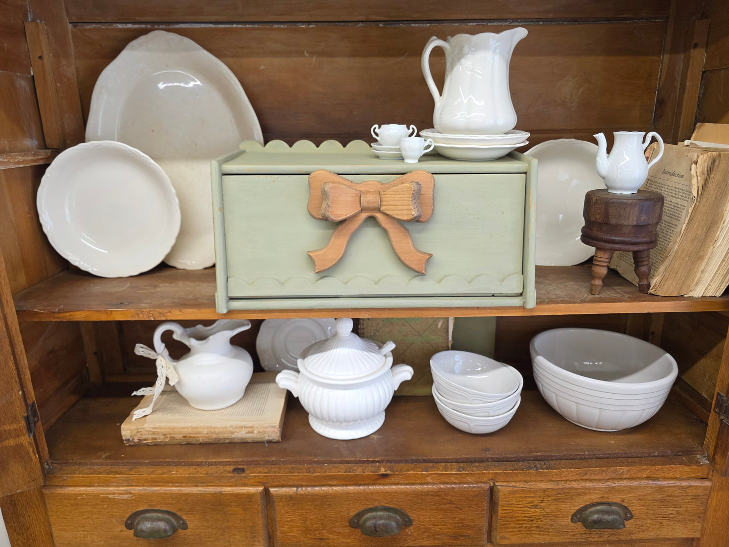 Green breadbox with scalloped details and large wooden bow