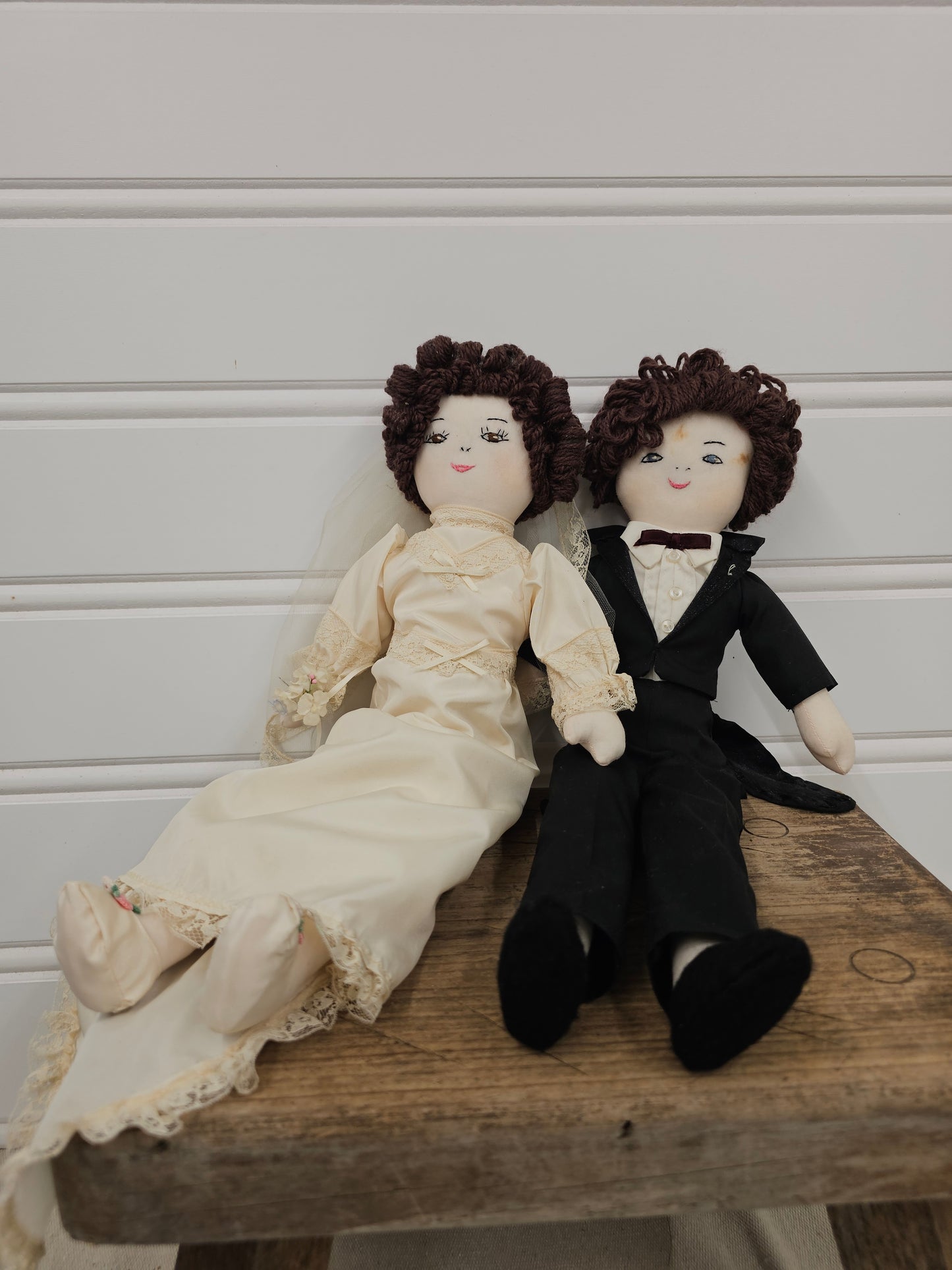 Doll couple in wedding attire on a wooden surface